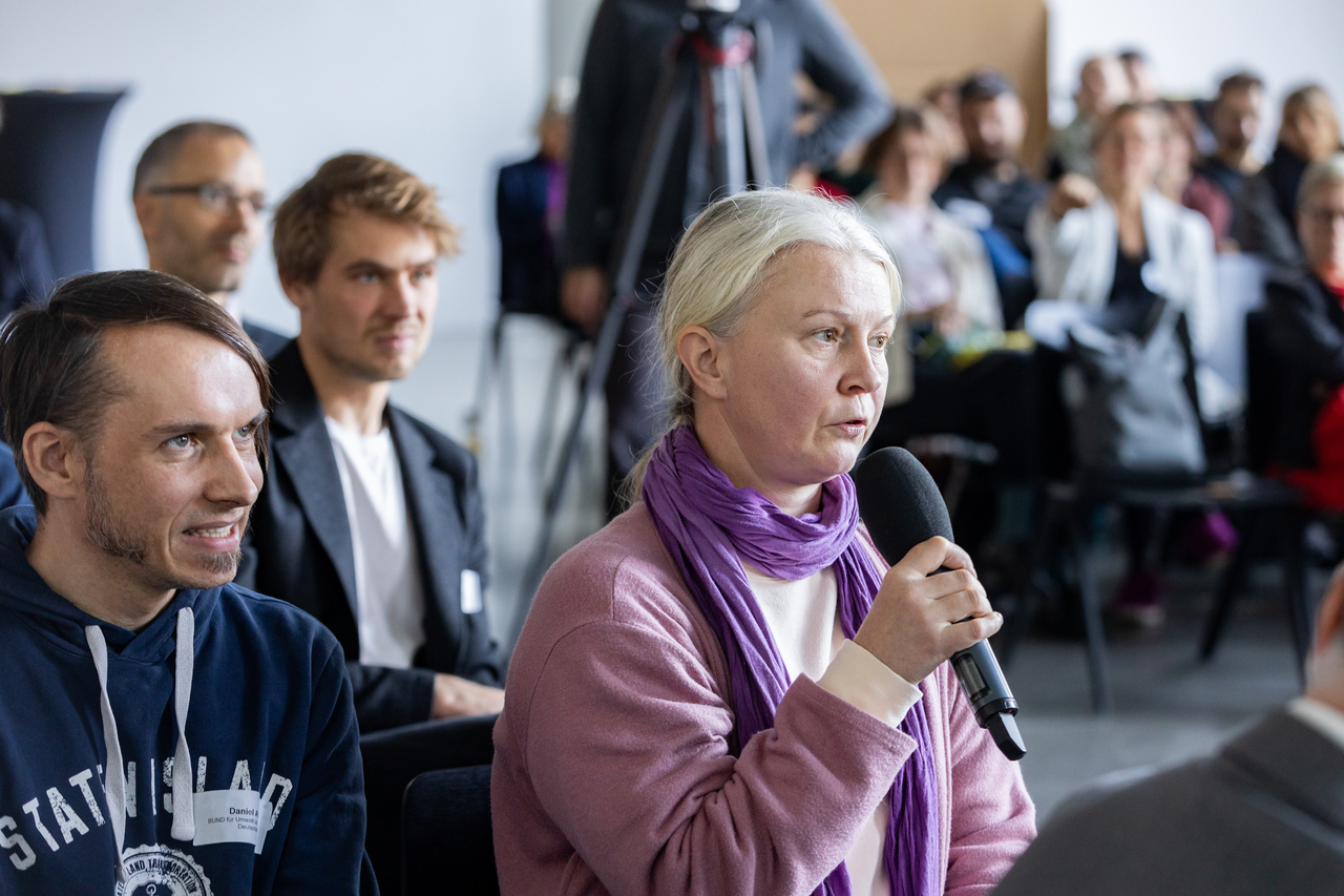 Eine Dame aus dem Publikum spricht ins Mikro